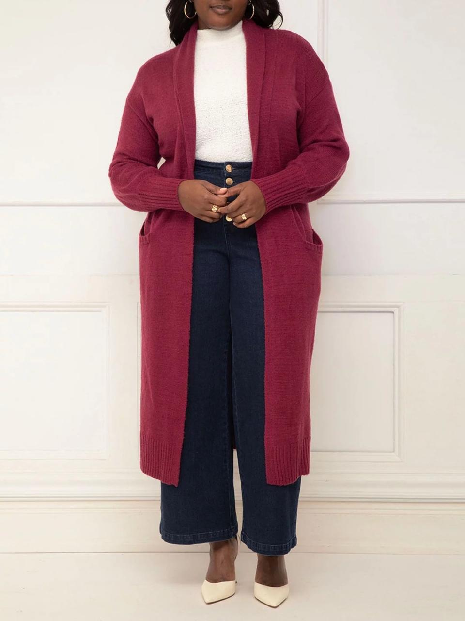 A model wearing the longline sweater open in a berry color