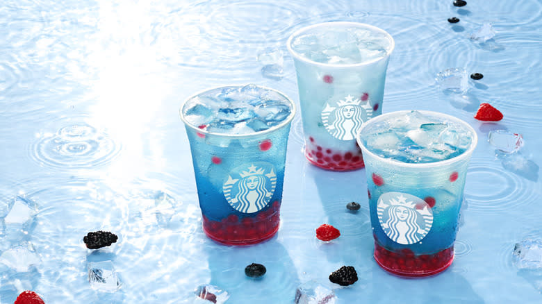 Three Starbucks Summer-Berry Refresher beverages sitting in ice water