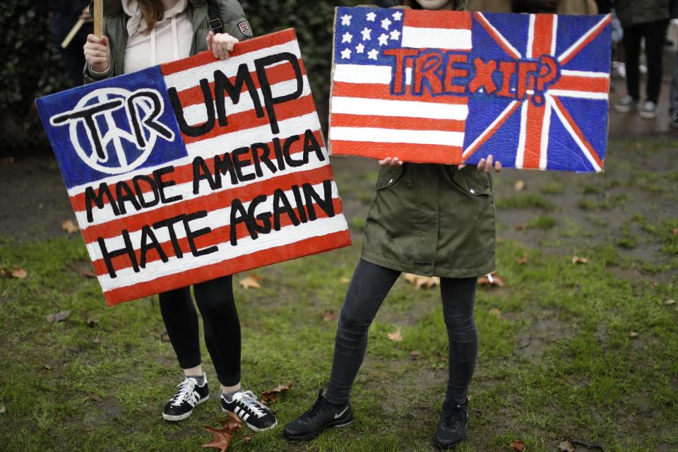 Demonstrators hold placards as they take part in a protest outside the U.S. embassy in London, against U.S. President Donald Trump's ban on travellers and immigrants from seven predominantly Muslim countries entering the U.S., Saturday, Feb. 4, 2017. (AP Photo/Matt Dunham)