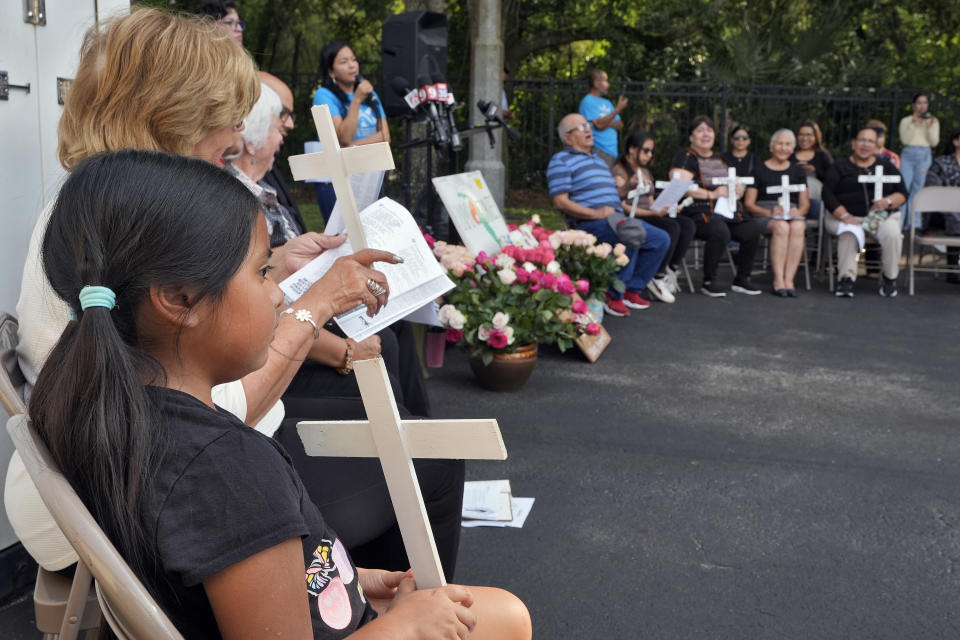 Mourners pray during a memorial vigil at The Farmworkers Association Wednesday, May 15, 2024, in Apopka, Fla. Eight farmworkers from Mexico were killed and dozens more were injured when a pickup truck and bus collided early Tuesday morning in Dunnellon, Fla. (AP Photo/Chris O'Meara)