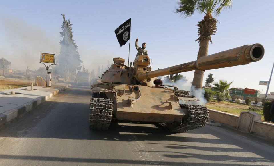 Militant Islamist fighters on a tank take part in a military parade along the streets of northern Raqqa province in June 2014. (Photo: Reuters)