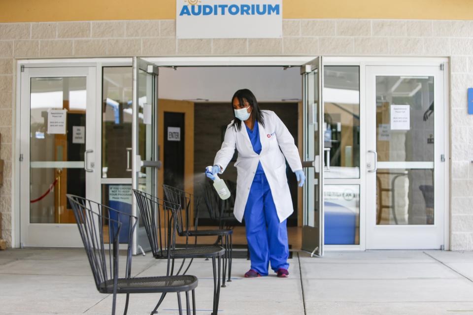 Dr. Yomaris Pena, of SOMOS Community Care in New York, disinfects chairs at the new COVID-19 testing site at Pinellas Community Church on Wednesday, July 29, 2020, in St. Petersburg, Fla. A new free testing site opened Wednesday in south St. Petersburg with the help of New York Gov. Andrew Cuomo. Cuomo sent 7,500 tests to seed the site at the church. Tests are by appointment only, but don't require symptoms or exposure. And since appointments are required, the testing site doesn't require those seeking a test to wait in line or come in a vehicle. (Jonah Hinebaugh/Tampa Bay Times via AP)