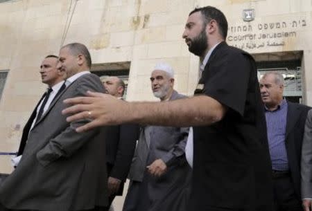 Leader of the northern Islamic Movement Sheikh Raed Salah (C), accompanied by Israeli Ex-parliament member Mohammad Barakeh (R), walks out of the district court in Jerusalem October 27, 2015. REUTERS/Ammar Awad