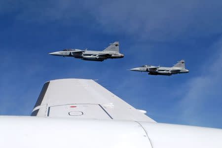 Saab JAS 39C Gripen fighter jets from F17 Wing of the Swedish Air Force demonstrate a mid-air interception over Sweden during a press tour of Swedish air and naval facilities on April 28, 2015. REUTERS/Tim Hepher