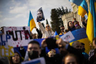 Pro-Ukrainian people hold banners and Ukrainian flags during a protest in Istanbul, Turkey, Saturday, Feb. 26, 2022, after Russian troops have launched an invasion on Ukraine. Russian troops stormed toward Ukraine's capital Saturday, and street fighting broke out as city officials urged residents to take shelter. (AP Photo/Francisco Seco)