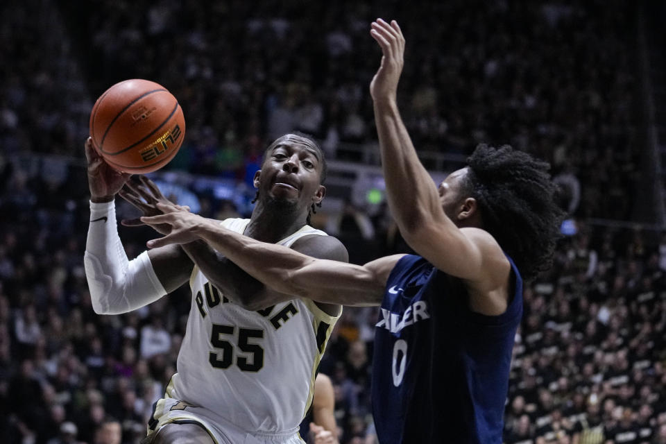 Purdue guard Lance Jones (55) is fouled as he shoots over Xavier guard Trey Green (0) during the second half of an NCAA college basketball game in West Lafayette, Ind., Monday, Nov. 13, 2023. Purdue defeated Xavier 83-71. (AP Photo/Michael Conroy)