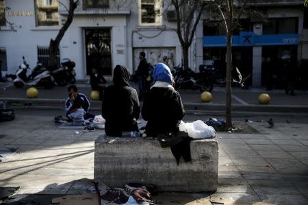 Two migrants sit on a marble bench on Victoria Square, where stranded refugees and migrants, most of them Afghans, find shelter in Athens, Greece, March 3, 2016. REUTERS/Alkis Konstantinidis