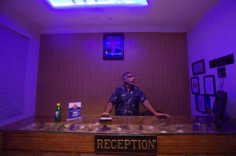 Kashmiri hotel manager Khurshid Ahmed stands at the reception counter of Hotel Standard during lockdown to stop the spread of the coronavirus in Srinagar, Indian controlled Kashmir, July 15, 2020. The seven-decades old hotel had a staff of 30 but now they're down to just three, according to Khurshid. The only activity inside the once-bustling place is by the cleaning staff. Indian-controlled Kashmir's economy is yet to recover from a colossal loss a year after New Delhi scrapped the disputed region's autonomous status and divided it into two federally governed territories. (AP Photo/Mukhtar Khan)