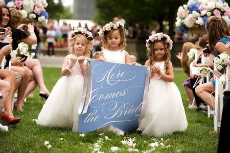 Flower girls carrying sign.