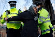 Police officers detain a protestor during an anti-COVID-19 lockdown demonstration outside the Houses of Parliament in Westminster, central London on January 6, 2021. - Britain toughened its coronavirus restrictions on Tuesday, with England and Scotland going into lockdown and shutting schools, as surging cases have added to fears of a new virus variant. (Photo by Tolga Akmen / AFP) (Photo by TOLGA AKMEN/AFP via Getty Images)