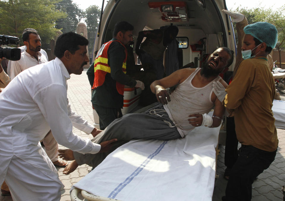 Hospital staff shift a man who was injured in a train fire, to a hospital in Multan, Pakistan, Thursday, Oct. 31, 2019. A massive fire engulfed three carriages of the train traveling in the country's eastern Punjab province (AP Photo/Asim Tanveer)