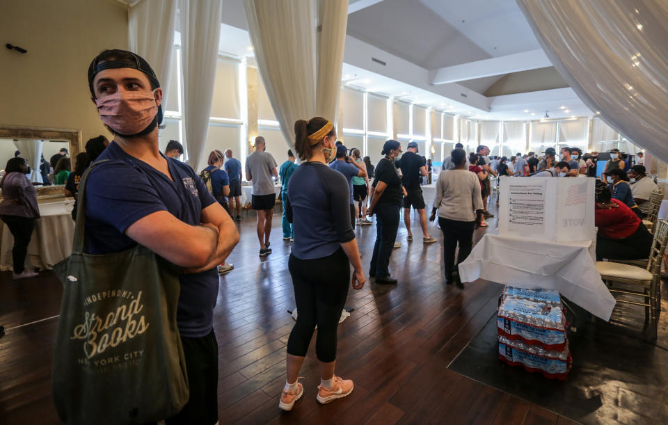 Voters wait in line to cast their ballots in the state's primary election at a polling place, Tuesday, June 9, 2020, in Atlanta, Ga. Some voting machines went dark and voters were left standing in long lines in humid weather as the waiting game played out. (AP Photo/Ron Harris)