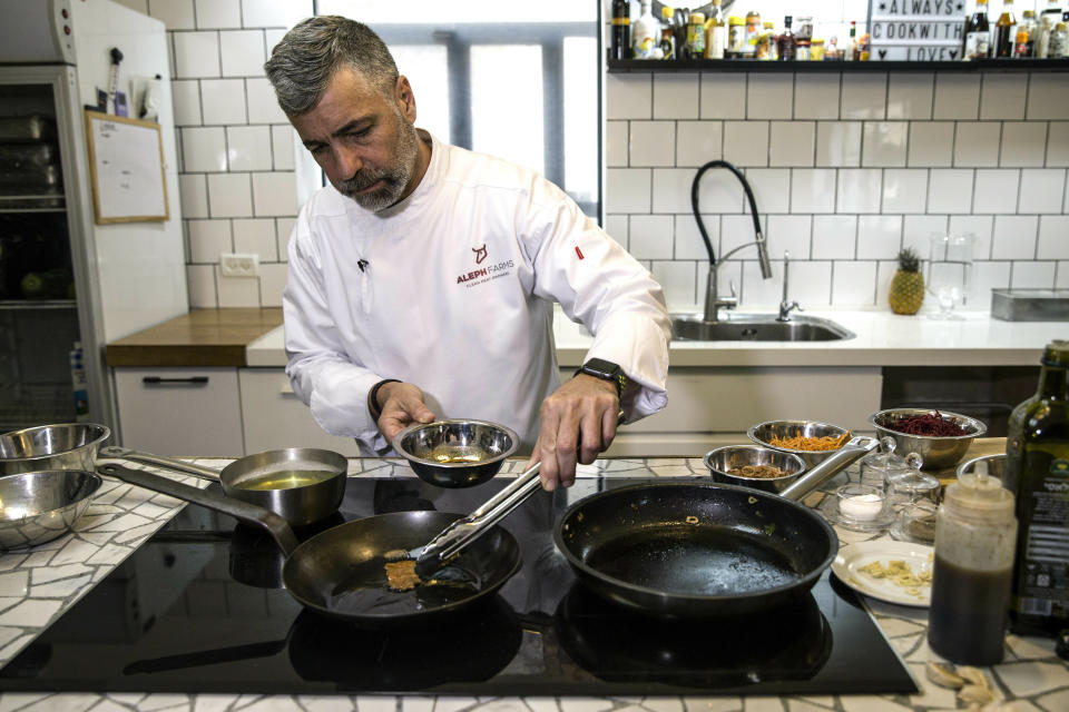 In this Wednesday, Jan. 16, 2019 photo, chef Amir Ilan prepares a lab-grown steak during a presentation by the Israeli company Aleph Farms, in Jaffa, Israel. Several Israeli start-ups have joined a handful of companies around the globe trying to develop lab-grown meat, something they see as a solution to the needs of the world’s ever-growing population and burgeoning demand for food. (AP Photo/Tsafrir Abayov)