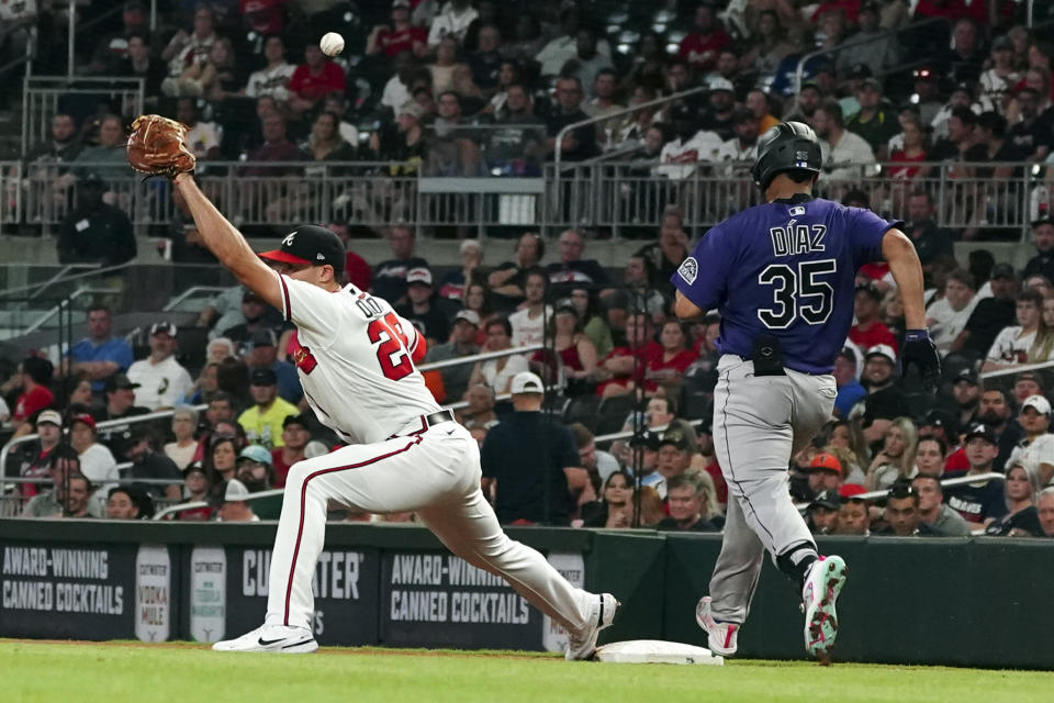 Colorado Rockies' Elias Diaz (35) is safe at first base as the ball gets past Atlanta Braves first baseman Matt Olson (28) in the eighth inning of a baseball game Thursday, Sept. 1, 2022, in Atlanta. (AP Photo/John Bazemore)