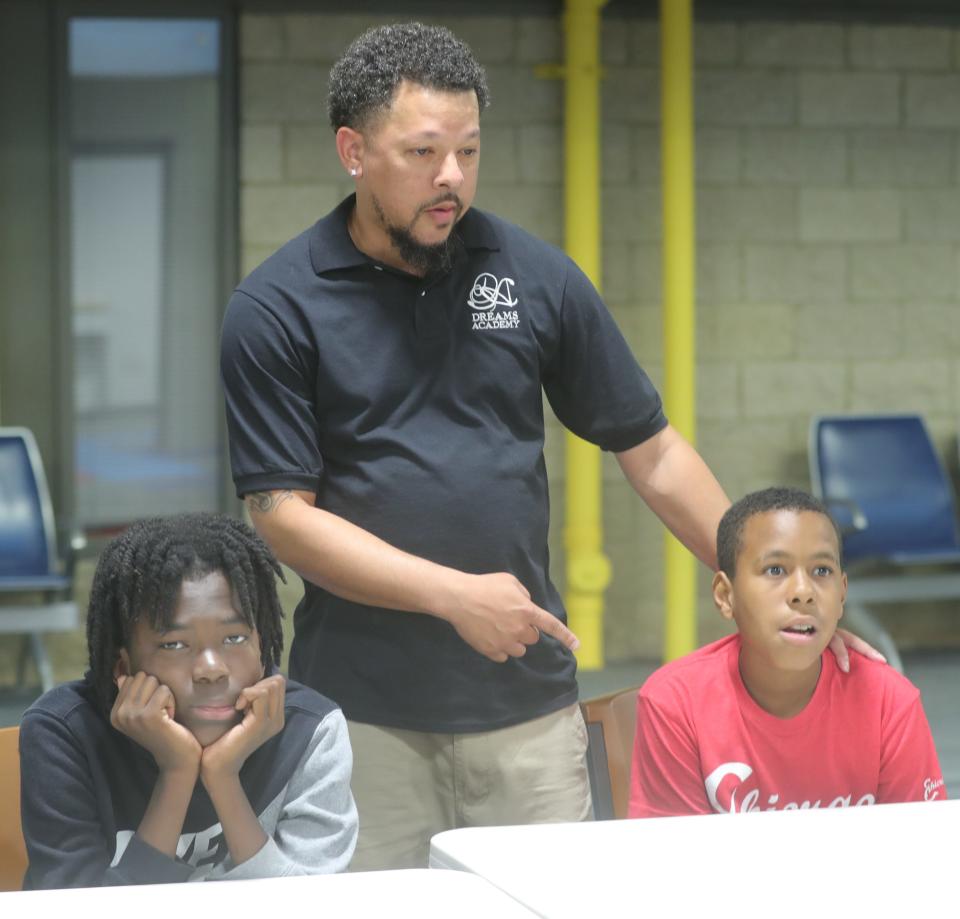 Brandon R. Scarborough, executive director of Dreams Academy, works with Braylon Lee and Donald Bailey, right, during a meeting at The House of the Lord on June 26 in Akron.