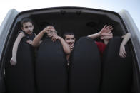 En esta fotografía del 13 de marzo de 2017, los migrantes sirios Fadi, de izquierda a derecha, Judy, Hosip y Mikl saludan desde la parte trasera de un vehículo en La Punta, Argentina. El UNICEF indicó que 2016 fue el peor año para los jóvenes sirios, con al menos 652 niños muertos. (AP Foto/Nicolás Aguilera)