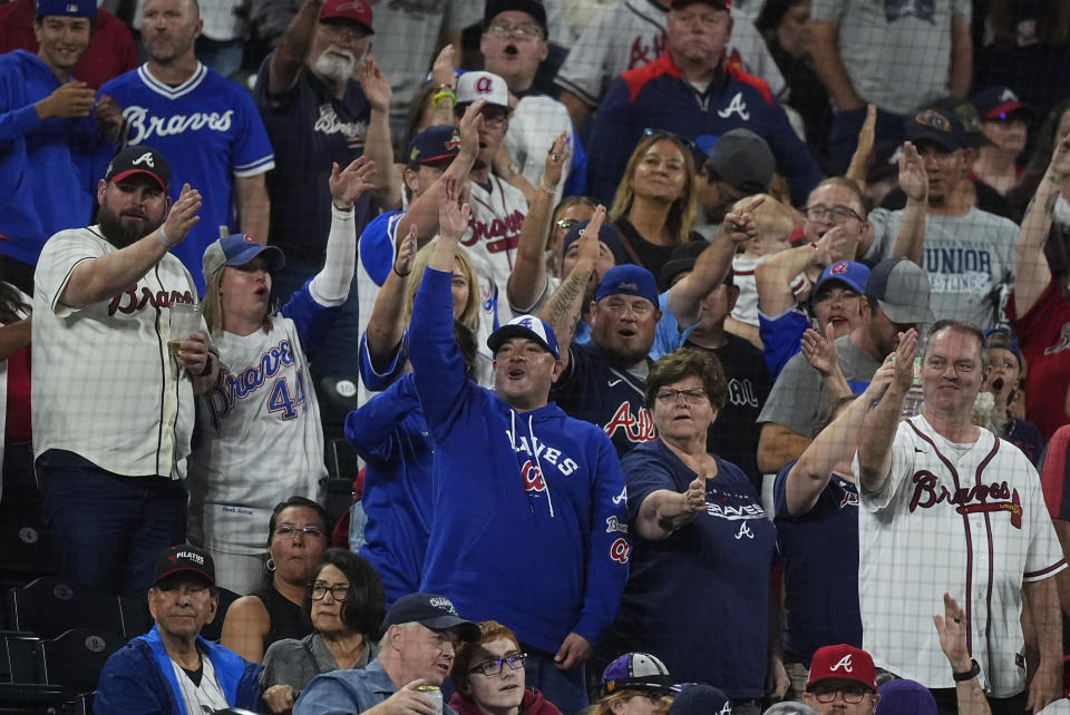 Atlanta Braves fans cheer as Atlanta Braves pitcher Raisel Iglesias gets Colorado Rockies' Elias Díaz to gorund out to end a baseball game Saturday, Aug. 10, 2024, in Denver. (AP Photo/David Zalubowski)