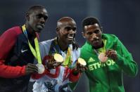 2016 Rio Olympics - Athletics - Victory Ceremony - Men's 5000m Victory Ceremony - Olympic Stadium - Rio de Janeiro, Brazil - 20/08/2016. Gold medalist Mo Farah (GBR) of Britain, silver medalist Paul Kipkemoi Chelimo (USA) of USA and bronze medalist Hagos Gebrhiwet (ETH) of Ethiopia pose with their medals. REUTERS/Dylan Martinez