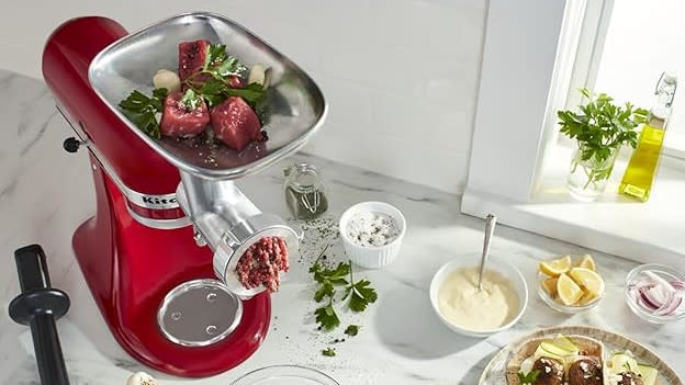 Red KitchenAid with a meat grinder attachment in a kitchen