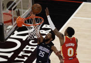 Orlando Magic guard Chasson Randle (25) lays up a shot past Atlanta Hawks' Brandon Goodwin, right, during the first half of an NBA basketball game Tuesday, April 20, 2021, in Atlanta. (AP Photo/Ben Margot)