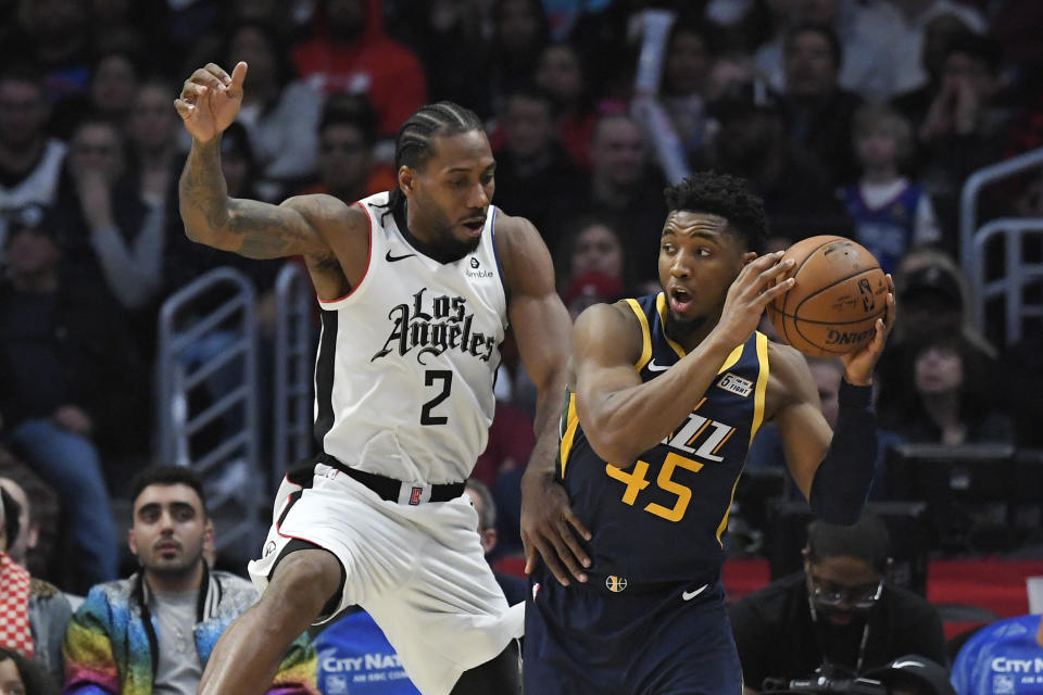 Los Angeles Clippers forward Kawhi Leonard, left, defends against Utah Jazz guard Donovan Mitchell during the second half of an NBA basketball game Saturday, Dec. 28, 2019, in Los Angeles. The Jazz won 120-107. (AP Photo/Mark J. Terrill)