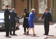Britain's Prime Minister Theresa May, second right, with her husband Philip May, second left, are greeted by Rt Hon Edward Young, private secretary to the Queen, and Major Nana Twumasi-Ankrah, Household Cavalry Regiment, as she arrives at Buckingham Palace in London for an audience with Queen Elizabeth II to formally resign as Prime Minister, Wednesday July 24, 2019. Boris Johnson will replace May as Prime Minister later Wednesday, following her resignation last month after Parliament repeatedly rejected the Brexit withdrawal agreement she struck with the European Union. (Yui Mok/pool via AP)