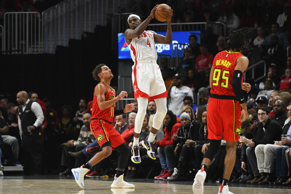 Houston Rockets forward Danuel House Jr.(4) goes high to catch a pass as Atlanta Hawks guard Trae Young (11) defends during the first half of an NBA basketball game Wednesday, Jan. 8, 2020, in Atlanta. (AP Photo/John Amis)