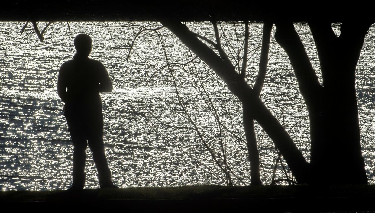 Sunlight sparkles on the waters of the deep water channel as Niea Turner of Stockton enjoys the warmth of the sunshine at Buckley Cove Park in Stockton. 