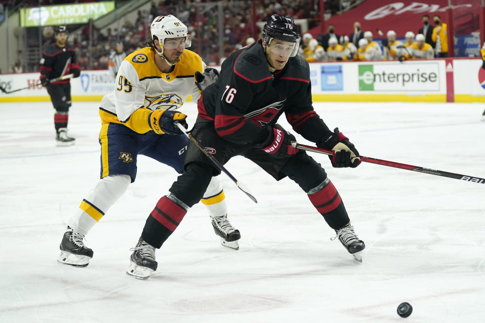 Nashville Predators center Matt Duchene (95) and Carolina Hurricanes defenseman Cavan Fitzgerald (76) chase the puck during the first period in Game 1 of an NHL hockey Stanley Cup first-round playoff series in Raleigh, N.C., Monday, May 17, 2021. (AP Photo/Gerry Broome)