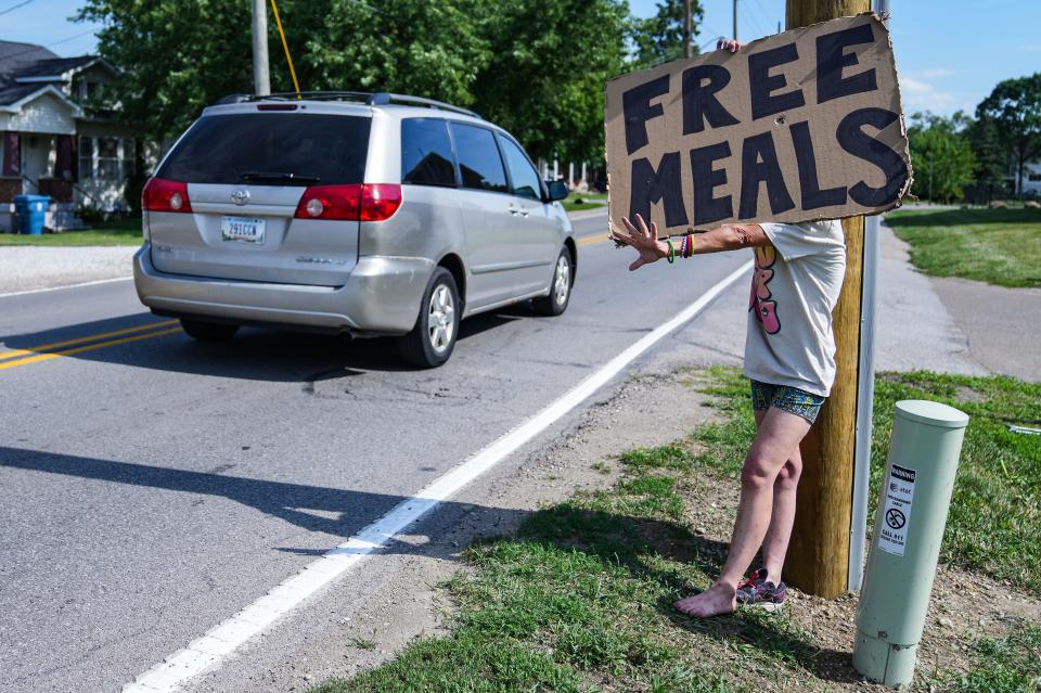 Deanna Byers holds a sign for free meals Wednesday, July 12, 2023, at Lynhurst Baptist Church in Indianapolis. 