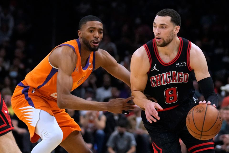Chicago Bulls guard Zach LaVine (8) drives on Phoenix Suns forward Mikal Bridges during the first half of an NBA basketball game Friday, March 18, 2022, in Phoenix.