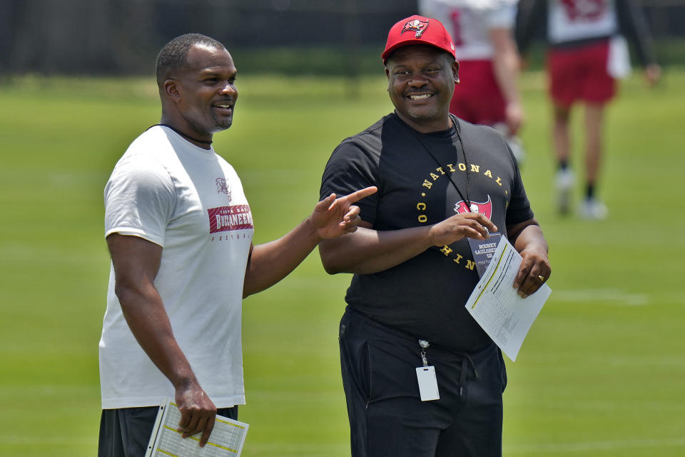 Williams Henry, left, defensive coordinator/safeties coach at Southeastern University, talks to Nathan Griffin, defensive coordinator/defensive line coach at Vandegrift High School in Texas, as they watch Tampa Bay Buccaneers players at the NFL football team's rookie camp, Friday, May 10, 2024, in Tampa, Fla. Twenty-five aspiring NFL coaches, with wide-ranging backgrounds, joined together at the inaugural Tampa Bay Buccaneers National Coaching Academy. (AP Photo/Chris O'Meara)