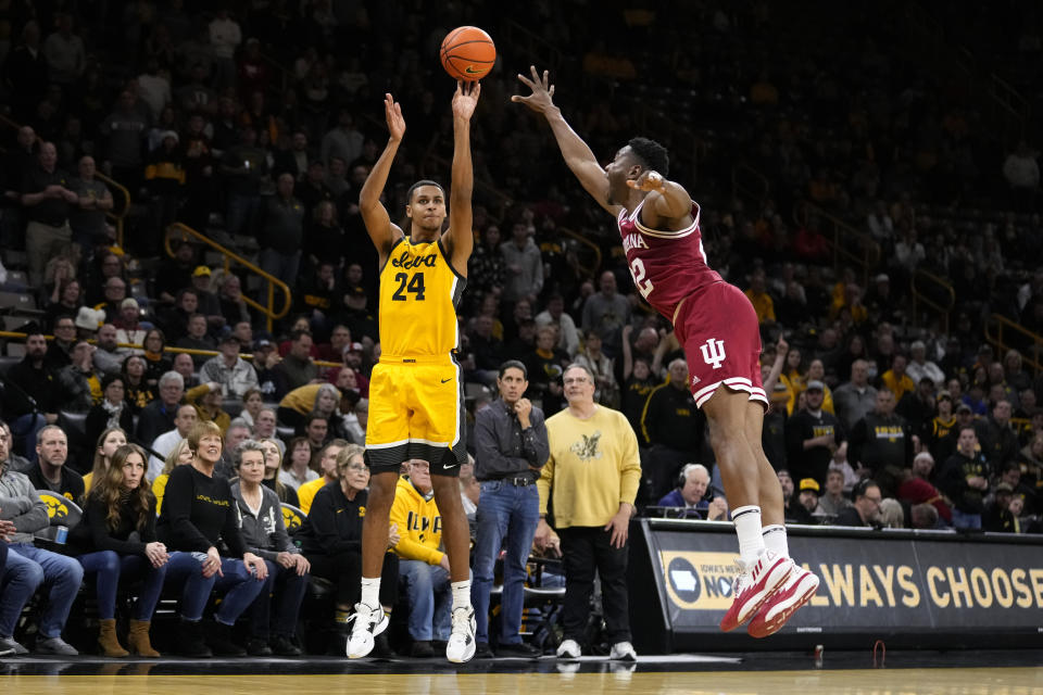 Iowa forward Kris Murray (24) shoots a 3-point basket ahead of Indiana forward Jordan Geronimo, right, during the second half of an NCAA college basketball game, Thursday, Jan. 5, 2023, in Iowa City, Iowa. (AP Photo/Charlie Neibergall)