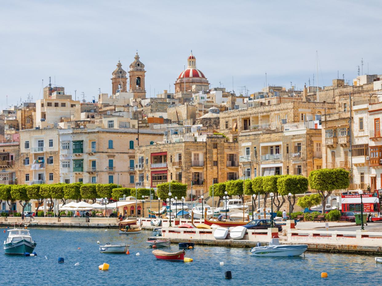 Buildings along the water in Valletta, Malta. There are boats in the water.