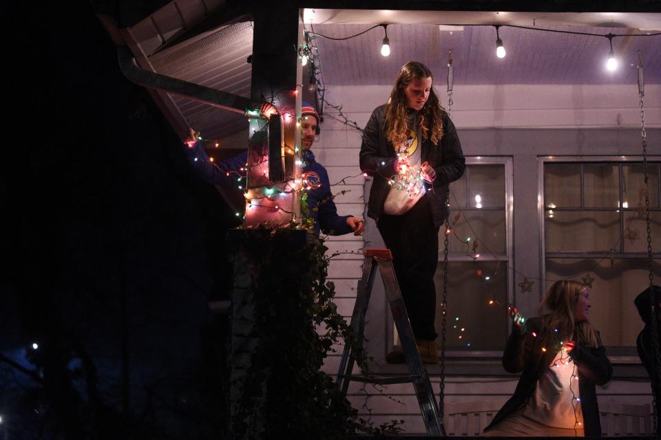 At center Ruby Miller of Sequoyah Hills Presbyterian, assists student ministries director Brandon Bajema, in directing the porch of a home during, Light Up Lonsdale, put on by Thrive, in Lonsdale, Wednesday, Nov. 29, 2023.