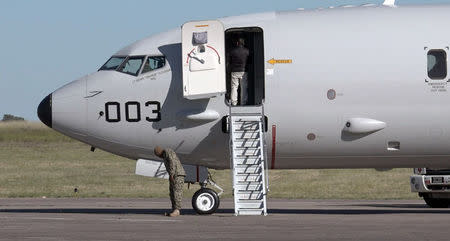 A member of the U.S. Navy stands next to the Boeing P-8A Poseidon plane before its departure to take part in the search for the ARA San Juan submarine missing at sea, at a military air base in Bahia Blanca, Argentina November 22, 2017. Picture taken November 22, 2017. REUTERS/Magali Cervantes