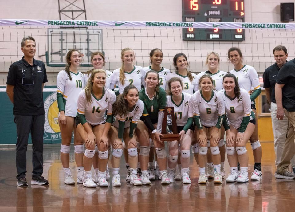 The Crusaders pose with the trophy after their 3-2 victory in the Florida State University High School vs Pensacola Catholic High School District 1-3A volleyball tournament championship at Pensacola Catholic High School in Pensacola on Thursday, Oct. 21, 2021.