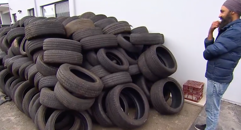 Sydney man Harjeet Singh Rai is pictured in front of the mountain of tyres at his Blacktown home, which he says he didn't order. 