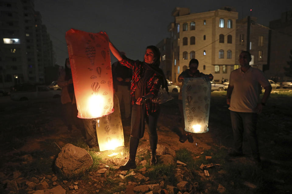 FILE - People light wish lanterns while celebrating Chaharshanbe Souri, or Wednesday Feast, an ancient Festival of Fire, on the eve of the last Wednesday of the solar Persian year, in Tehran, Iran, Tuesday, March 15, 2022. Among the world’s present-day religions, Zoroastrianism is one of the most ancient and historically influential. It was founded more than 3,000 years ago and became the major religion in Persia. (AP Photo/Vahid Salemi, File)