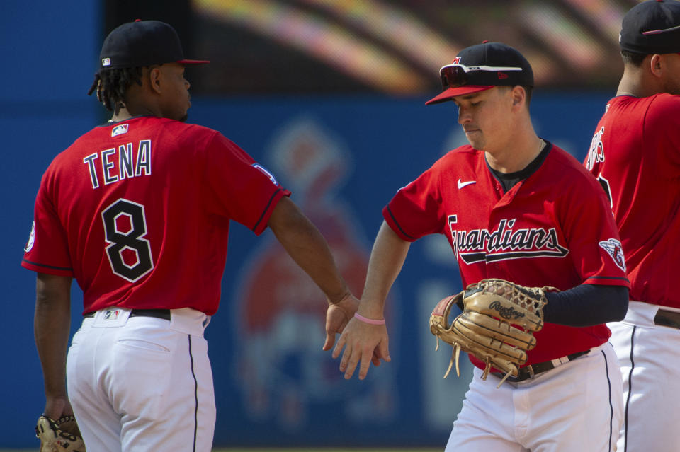 Cleveland Guardians' Jose Tena (8) and Will Brennan celebrate after a baseball game against the Texas Rangers in Cleveland, Sunday, Sept. 17, 2023. (AP Photo/Phil Long)