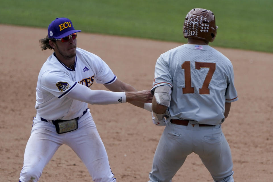 East Carolina first baseman Josh Moylan tags out Texas's Ivan Melendez at first during the ninth inning of an NCAA college super regional baseball game Friday, June 10, 2022, in Greenville, N.C. (AP Photo/Chris Carlson)