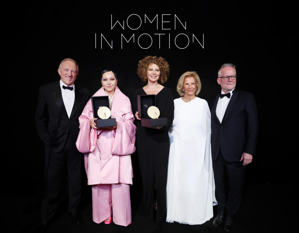 CANNES, FRANCE - MAY 19: (L-R) Emergent Talent award recipient Amanda Nell Eu (L2) and Woman In Motion award recipient Donna Langley (C) pose with their awards alongside François-Henri Pinault (L1), President of Cannes Film Festival, Iris Knobloch (R2) and President of Cannes Film Festival Thierry Frémaux (R1) during the Kering And Cannes Film Festival Official Dinner on May 19, 2024 in Cannes, France. (Photo by Vittorio Zunino Celotto/Getty Images for Kering)