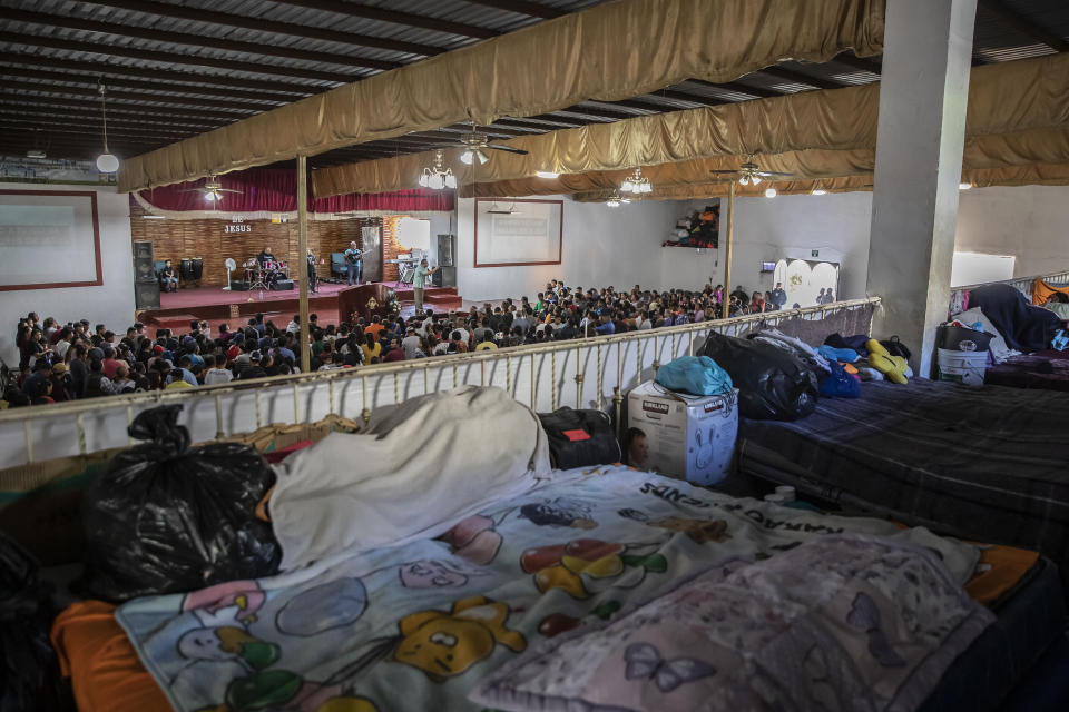 Beds cover an upper floor of the "Embajadores de Jesus" Christian migrant shelter as Mexican migrants, many from Michoacan state, attend a religious service on the bottom floor in Tijuana, Mexico, Tuesday, Sept. 26, 2023. While many places in Mexico provide shelter for migrants from other countries, some shelters in Tijuana have seen an influx of Mexicans fleeing violence, extortion and threats by organized crime. (AP Photo/Karen Castaneda)