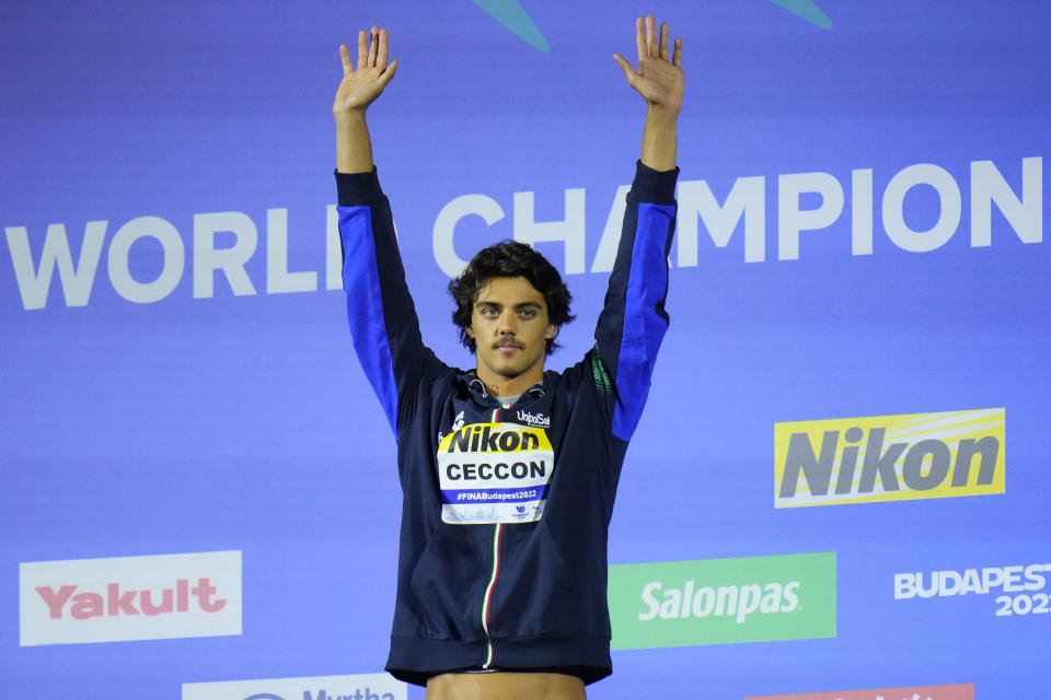Thomas Ceccon of Italy waves from the podium after winning the Men 100m Backstroke final setting a new world record at the 19th FINA World Championships in Budapest, Hungary, Monday, June 20, 2022. (AP Photo/Petr David Josek)