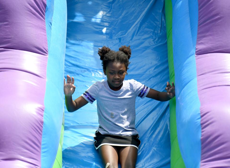 Madison Schnyders, 6, of Canton rides the slide Friday during EN-RICH-MENT'S third annual African American Arts Festival at Centennial Plaza in Canton.