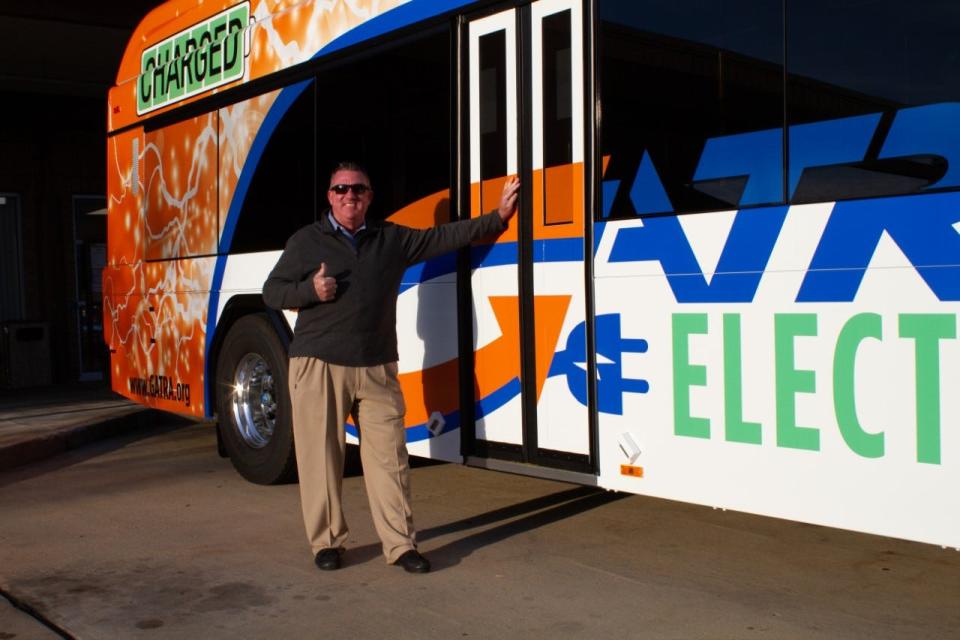 Mark A. Sousa, administrator of the Greater Attleboro Taunton Regional Transit Authority, stands in front of one of GATRA's new electric buses.