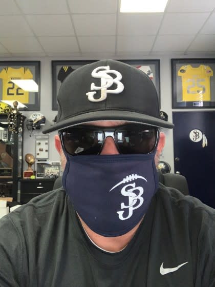 St. John Bosco football coach Jason Negro shows off his specially made mask.