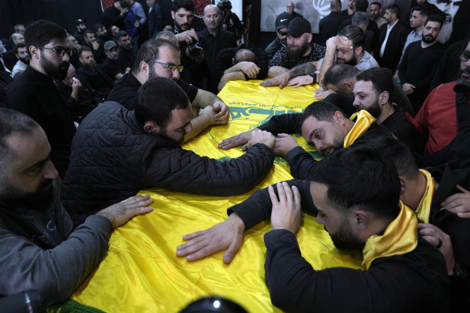 Mourners grieve over the coffin of, Ali Ahmad Hussein, who was killed by an Israeli strike in south Lebanon, during his funeral procession in the southern Beirut suburb of Dahiyeh, Lebanon, Monday, April 8, 2024. Israel's military says it has killed a commander of Hezbollah's secretive Radwan Force in southern Lebanon. (AP Photo/Bilal Hussein)