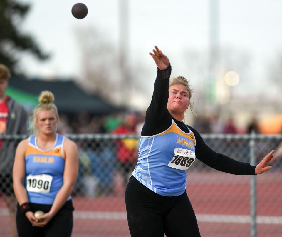 Hamlin's Gracelyn Leiseth warms up for the shot put at the Howard Wood Dakota Relays on Friday, May 6, 2022, in Sioux Falls. Leiseth won the event with a meet record and all-time state record toss of 48 feet, 11 inches. Looking on is Kami Wadsworth of Hamlin.