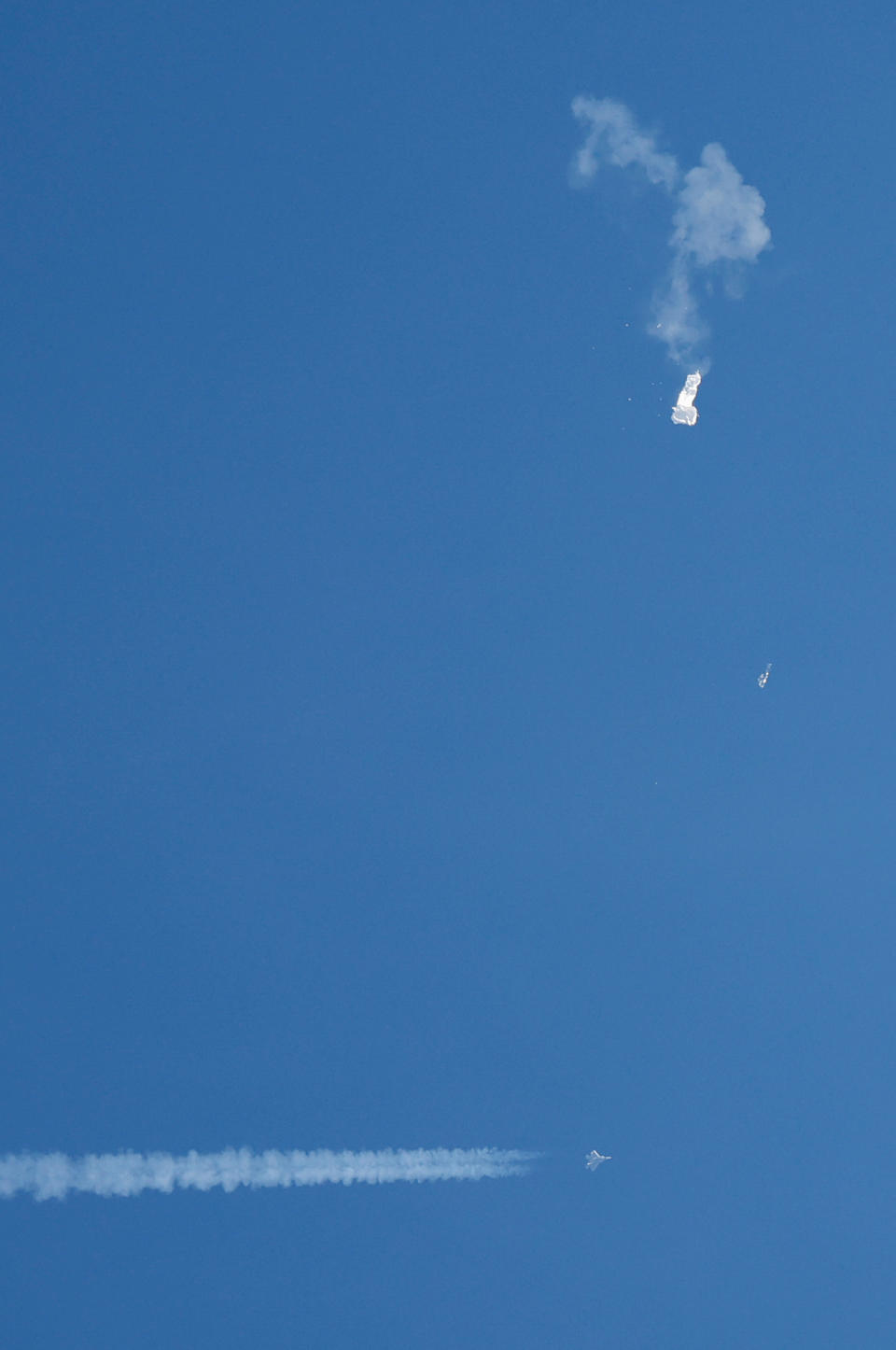 A jet flies by a suspected Chinese spy balloon after shooting it down off the coast in Surfside Beach, South Carolina, U.S. February 4, 2023.  REUTERS/Randall Hill